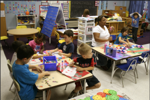 Kindergarten children sitting at tables playing.