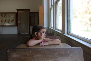 Child in a classroom looking out the window