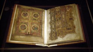 This photograph shows The Book of Kells opened, with ornate decorations on both of the pages.