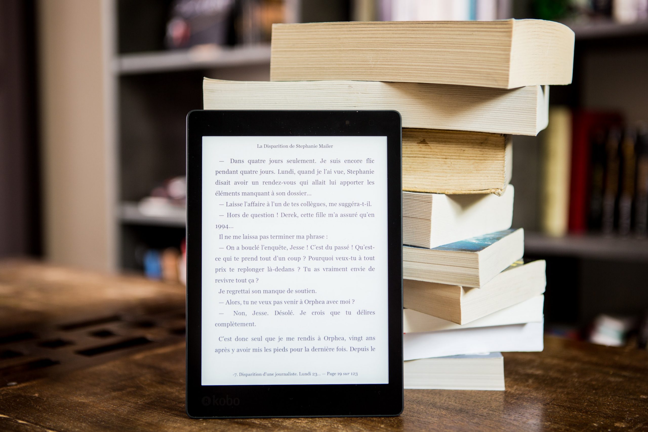 ereader next to a stack of print books