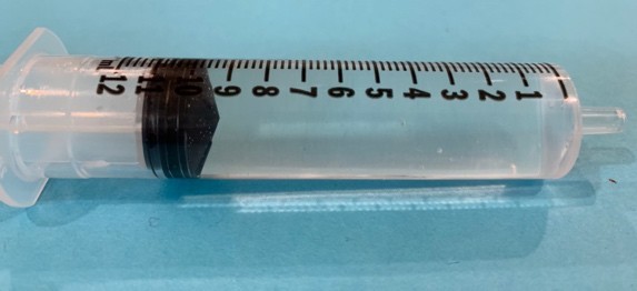 An image of liquid medicine in a syringe with metric markings.