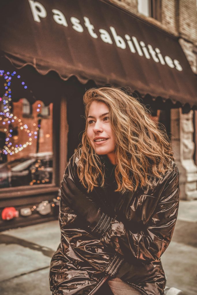 Young woman basking in cold near famous restaurant