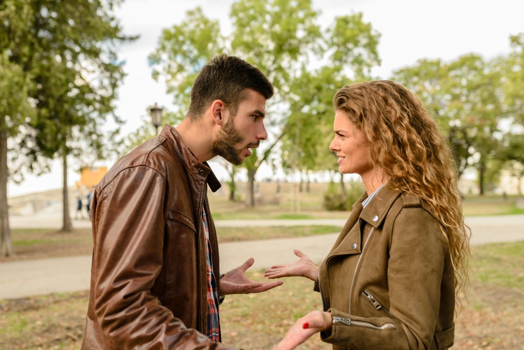 A man and a woman facing each other engaged in an argument.