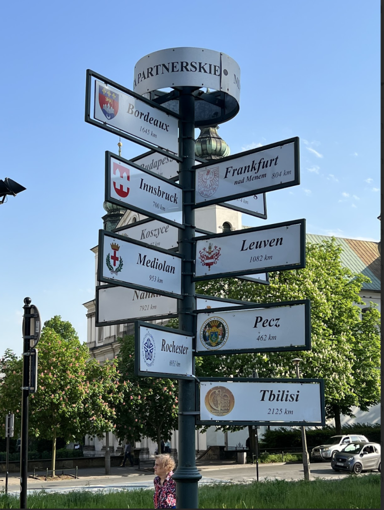 Signage showing the relative locations of cities in relation to Krakow, PL