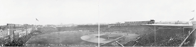 A photograph of Fenway Park showing a full view of the field and at the right the stands full of citizens.