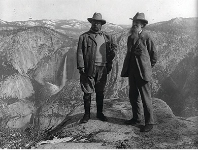 Photograph of Roosevelt and John Muir standing on mountain top in Yosemite National Park.