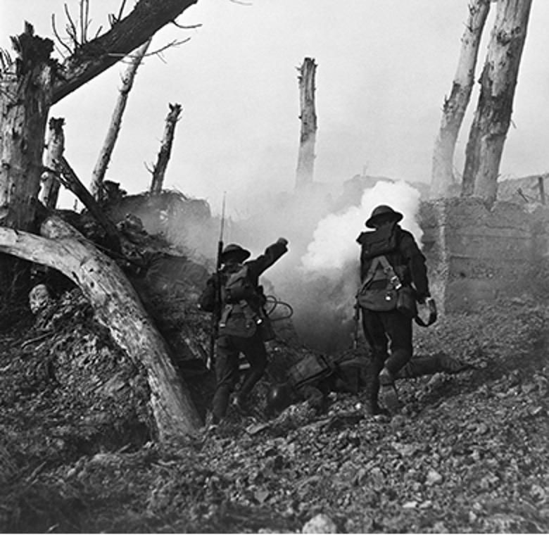 A black and white photo showing American soldiers in helmets and gear running past fallen German soldiers and towards a bunker during World War I on the Western Front.