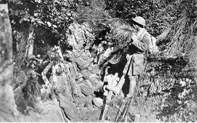 A black and white photo of soldiers in a trench. They are wearing helmets and looking out of the trench. This depicts trench warfare on the Western Front in 1918.