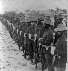 Image shows several rows of African American servicemen lined up for inspection.